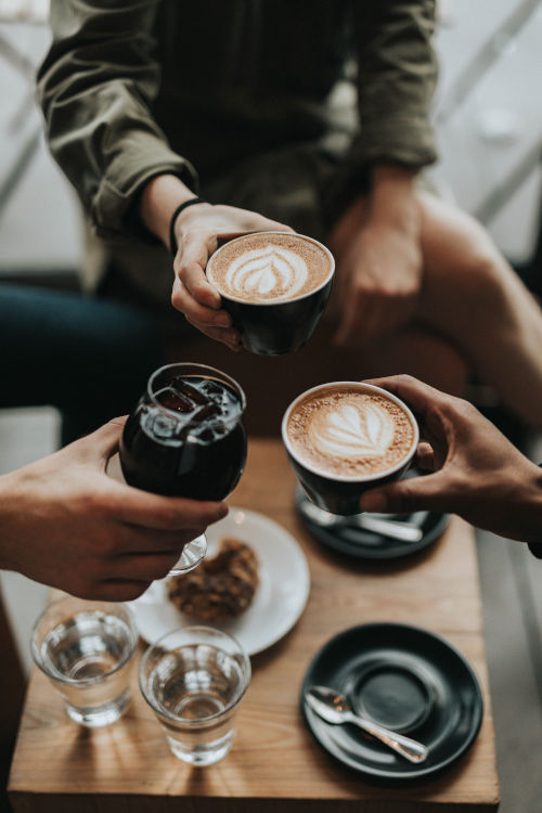 Bild von Freunden im Café die mit Getränken anstoßen